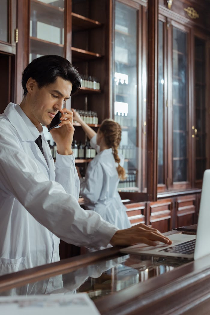 The Art of Drawing Readers In: Your attractive post title goes here Pharmacists working in a historic pharmacy, focusing on customer calls and inventory.